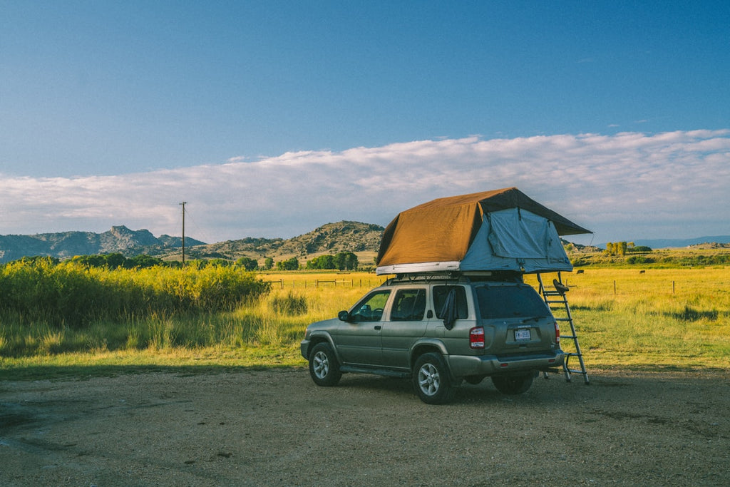 SUV with camping tent setup outdoors