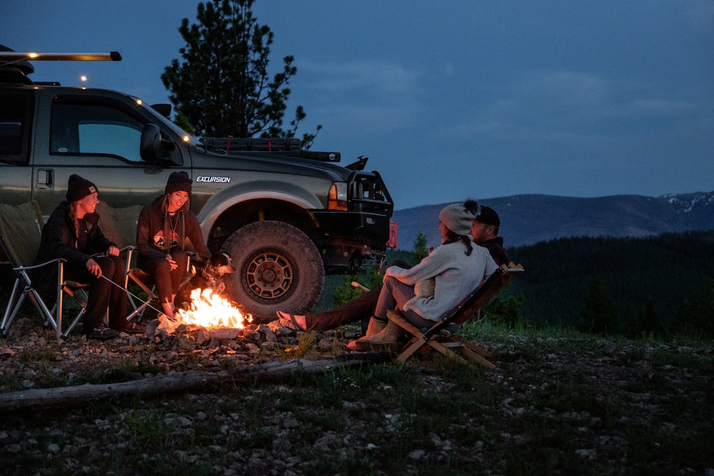 Camping setup next to Tesla at night — EV car camping lifestyle