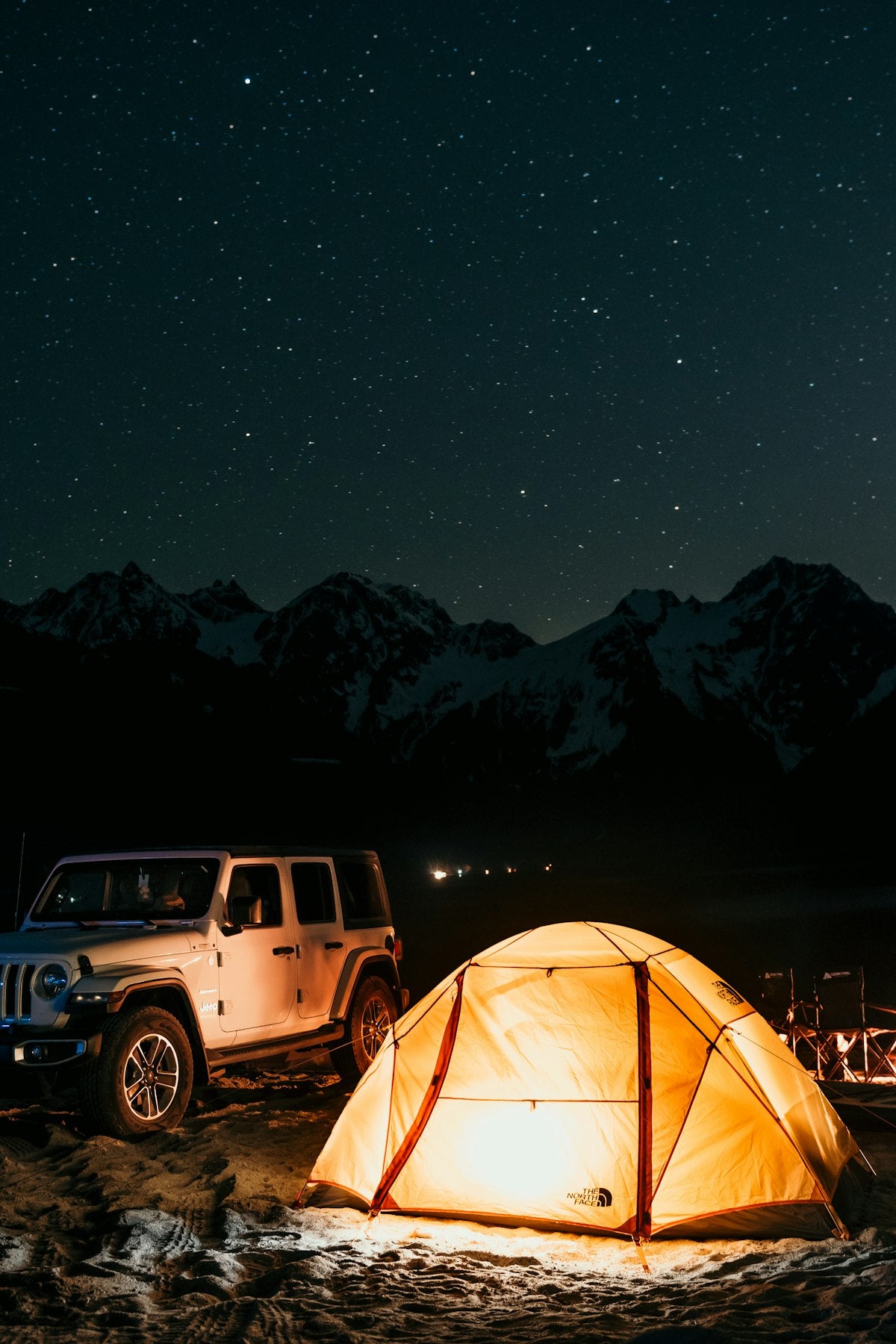 Camping tent with vehicle parked in mountain landscape